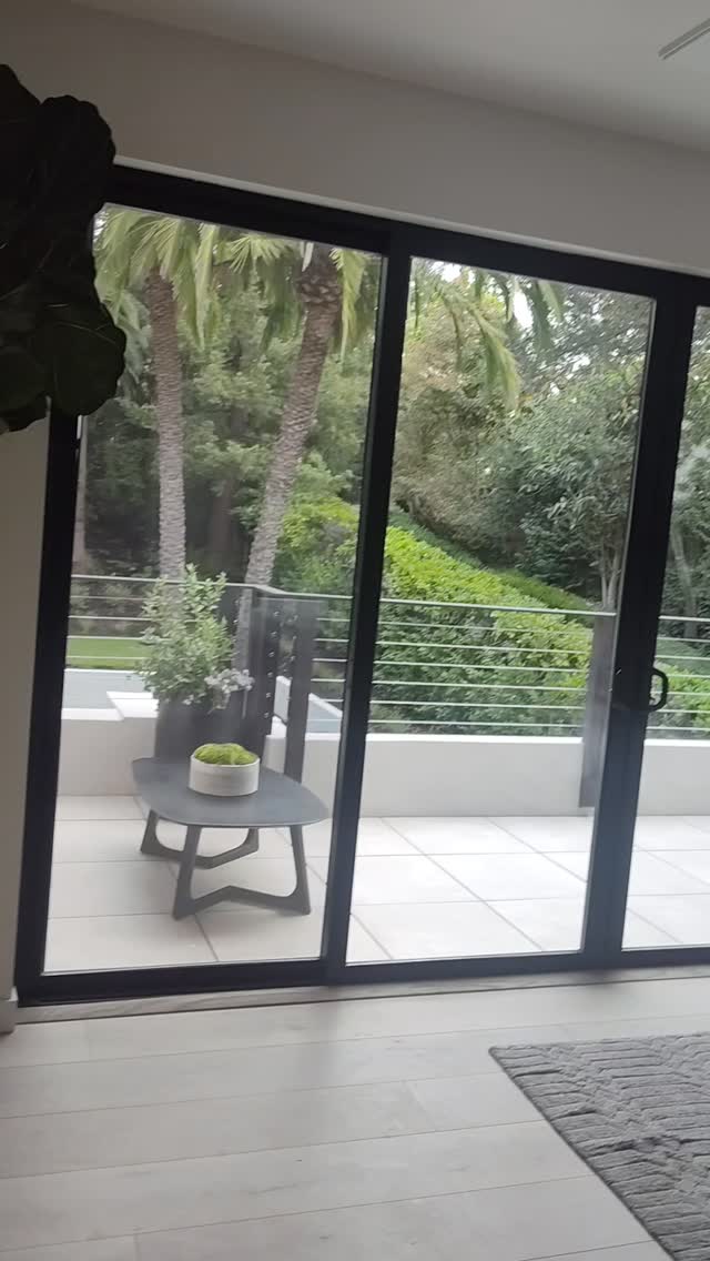 Large black-framed patio doors opening to a landscaped terrace